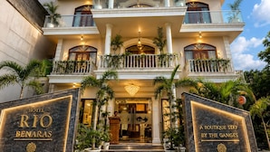 Un hotel de varios pisos con una entrada imponente, varios balcones y una fachada bien iluminada.