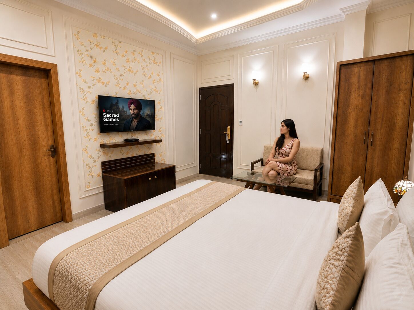 Ein Schlafzimmer mit einem großen Bett, einem an der Wand montierten Fernseher, einem Kleiderschrank und einer Sitzecke mit einer Couch.