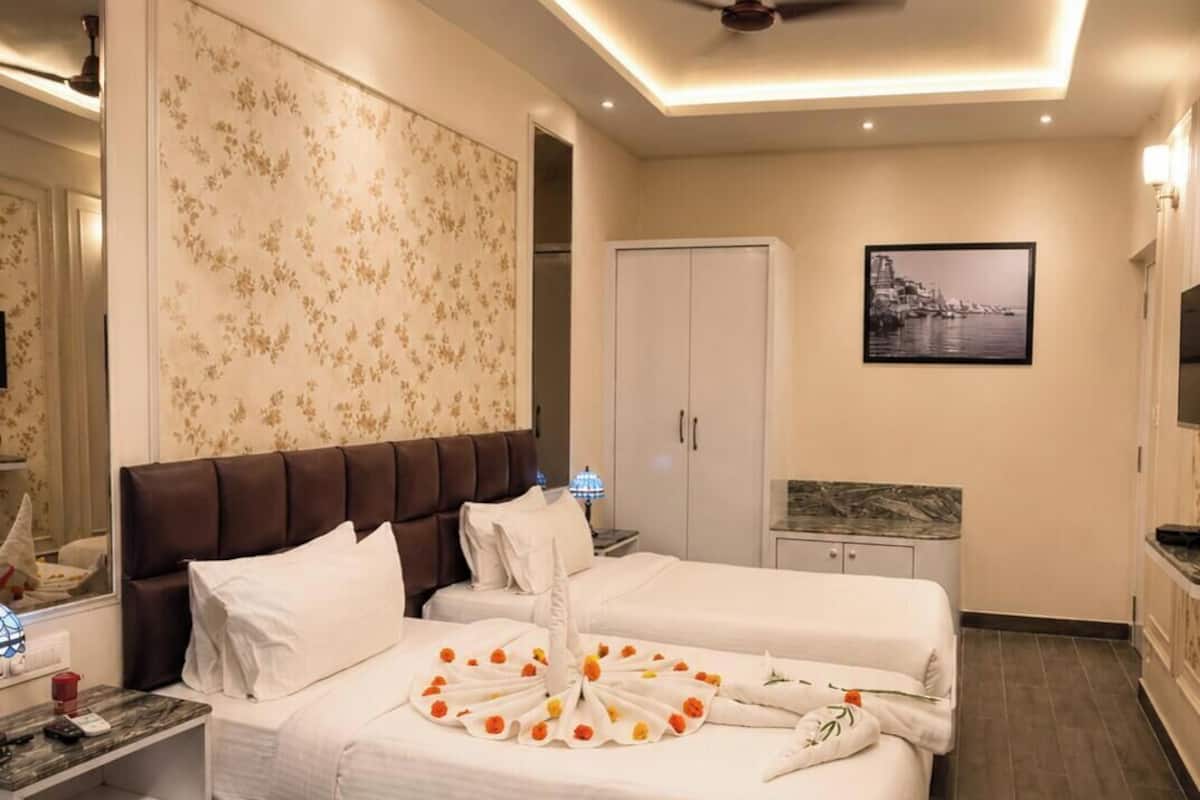 Una habitación de hotel con una cama grande, un armario, un escritorio y un ventilador de techo.