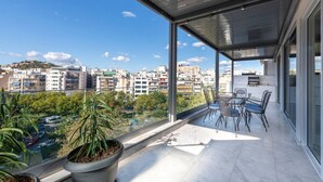 A balcony with a view of a cityscape, a table with chairs, and potted plants. - Phaedrus Living: City Center Luxury Flat N. Kosmos (Athina)