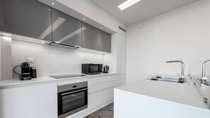 A modern kitchen with a built-in oven, microwave, and coffee maker. - Phaedrus Living: City Center Luxury Flat N. Kosmos (Athina)