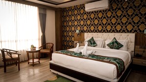A hotel room with a bed, a chair, a small table, and a window with curtains. - The Z Retreat and Spa (Gangtok)
