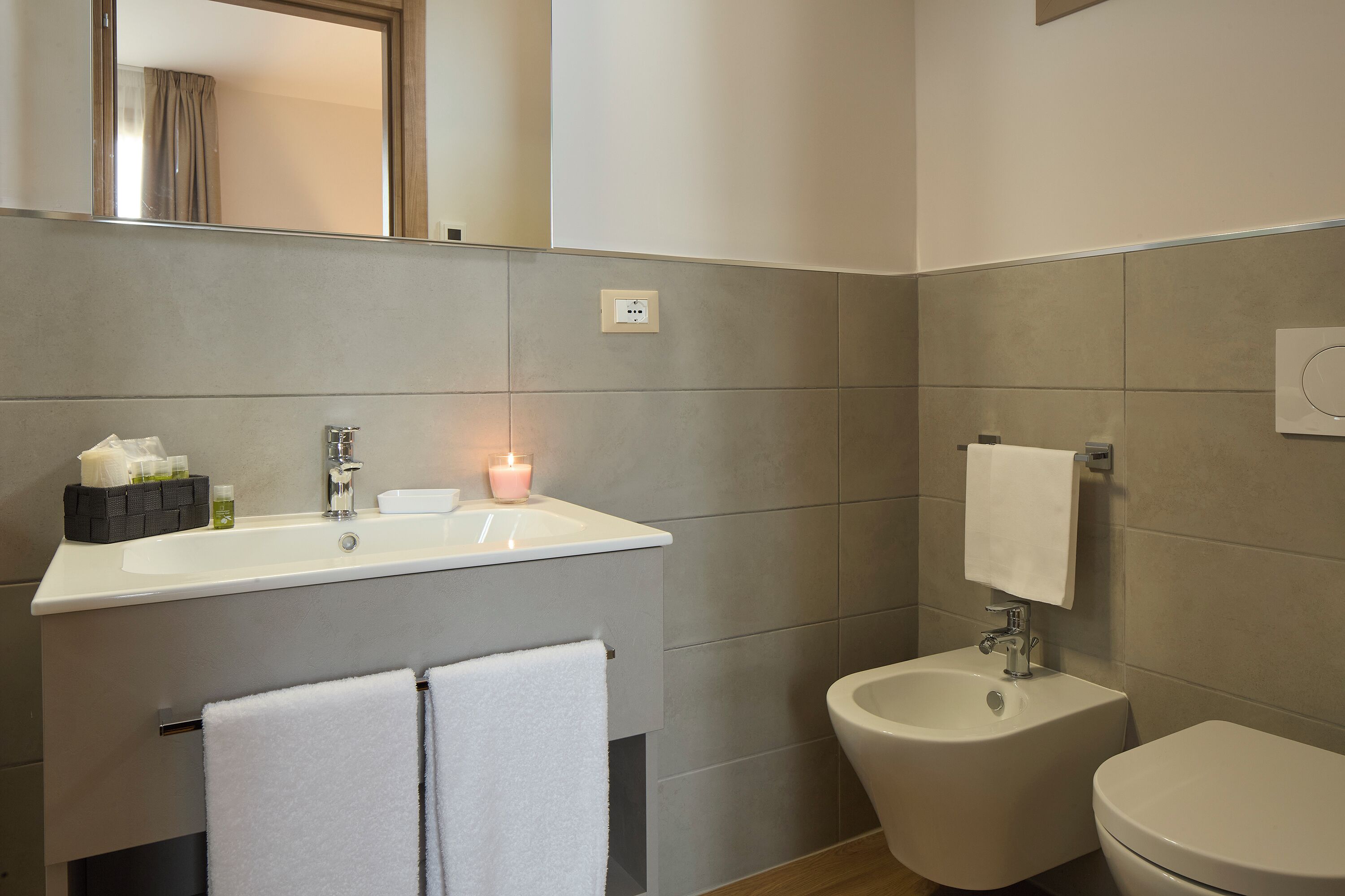 Une salle de bain équipée d’un lavabo, d’un bidet et de toilettes.