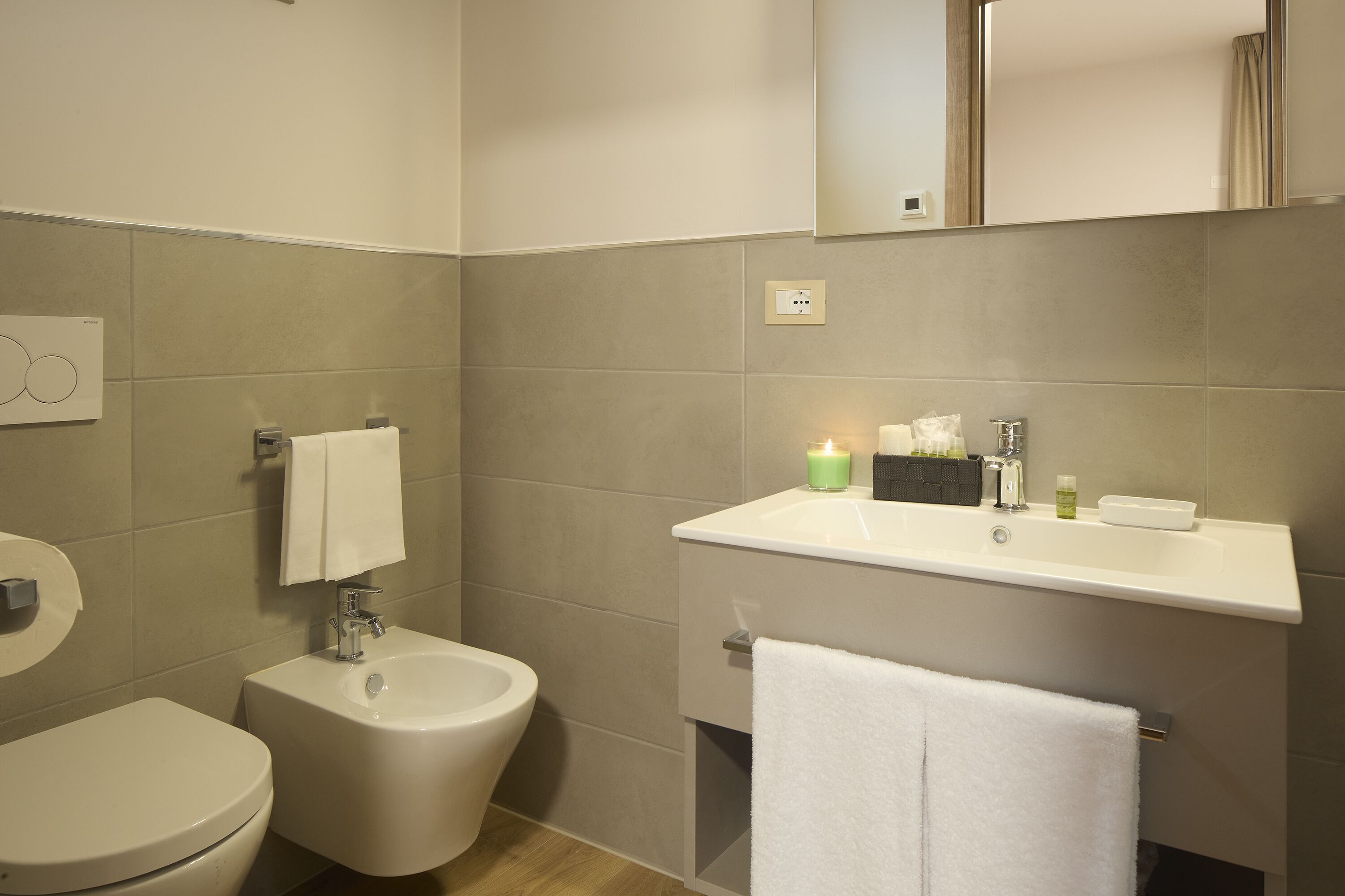 A bathroom with a toilet, bidet, and sink.