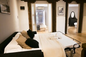 Ein Hotelzimmer mit Bett, Nachttisch, Spiegel und einer Tür zum Badezimmer.