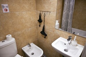 Ein Badezimmer mit Toilette, Bidet, Waschbecken und Spiegel.