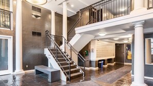 A spacious interior with a grand staircase, a large open area with a tiled floor, and a wall of mailboxes. - Seattle's Gem: Elegant 1BR in Belltown - Sleeps 4 (Seattle)