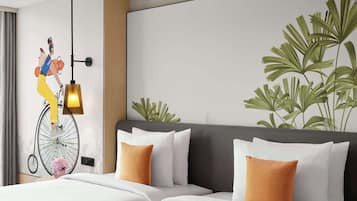 Una habitación de hotel con una cama grande, una lámpara de pared y un mural decorativo.