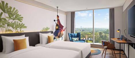 A hotel room with two beds, a desk with a laptop, a TV, and a large window offering a city view.
