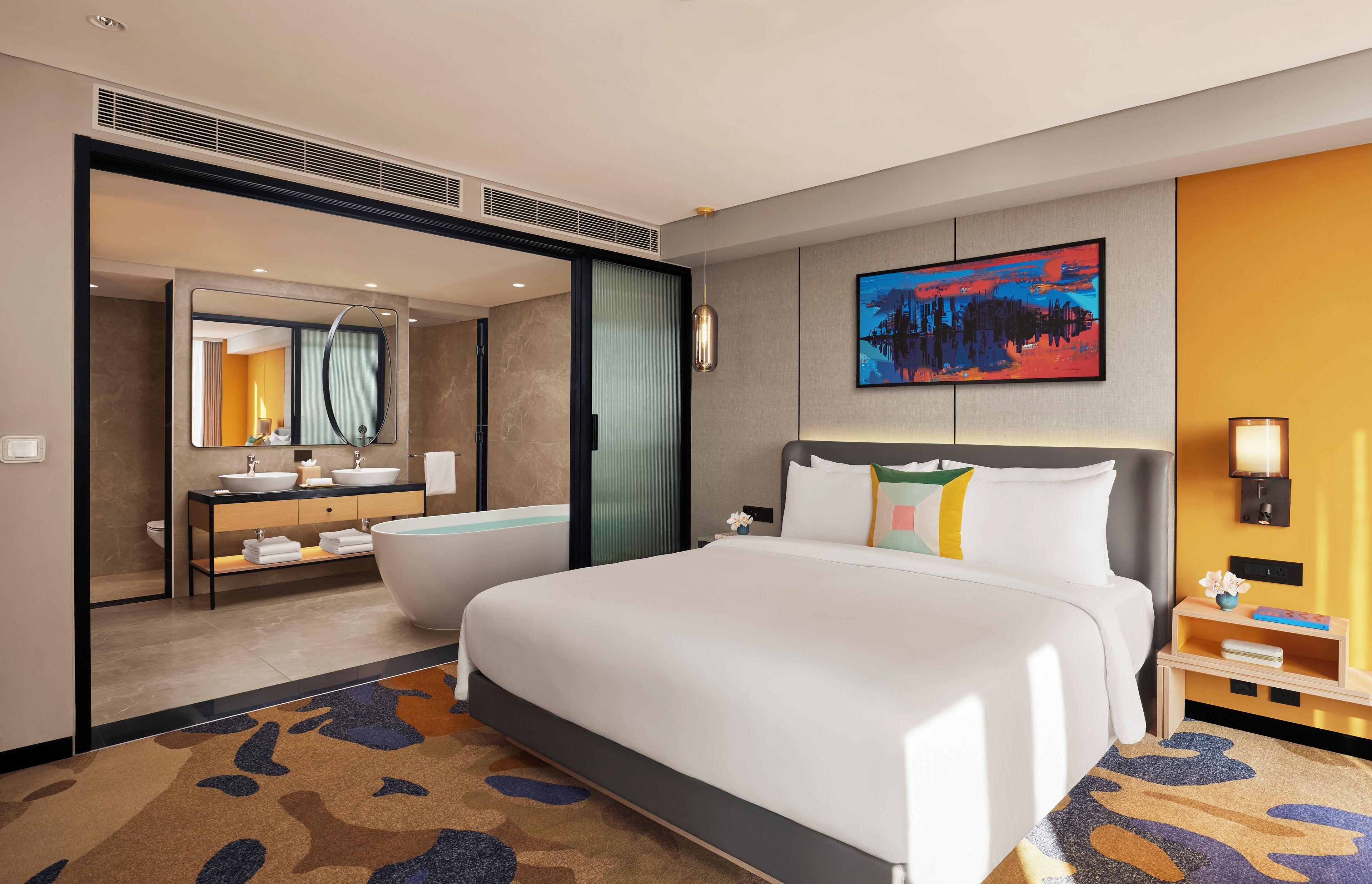 Habitación de hotel con una cama grande, baño con bañera, escritorio y un cuadro en la pared.