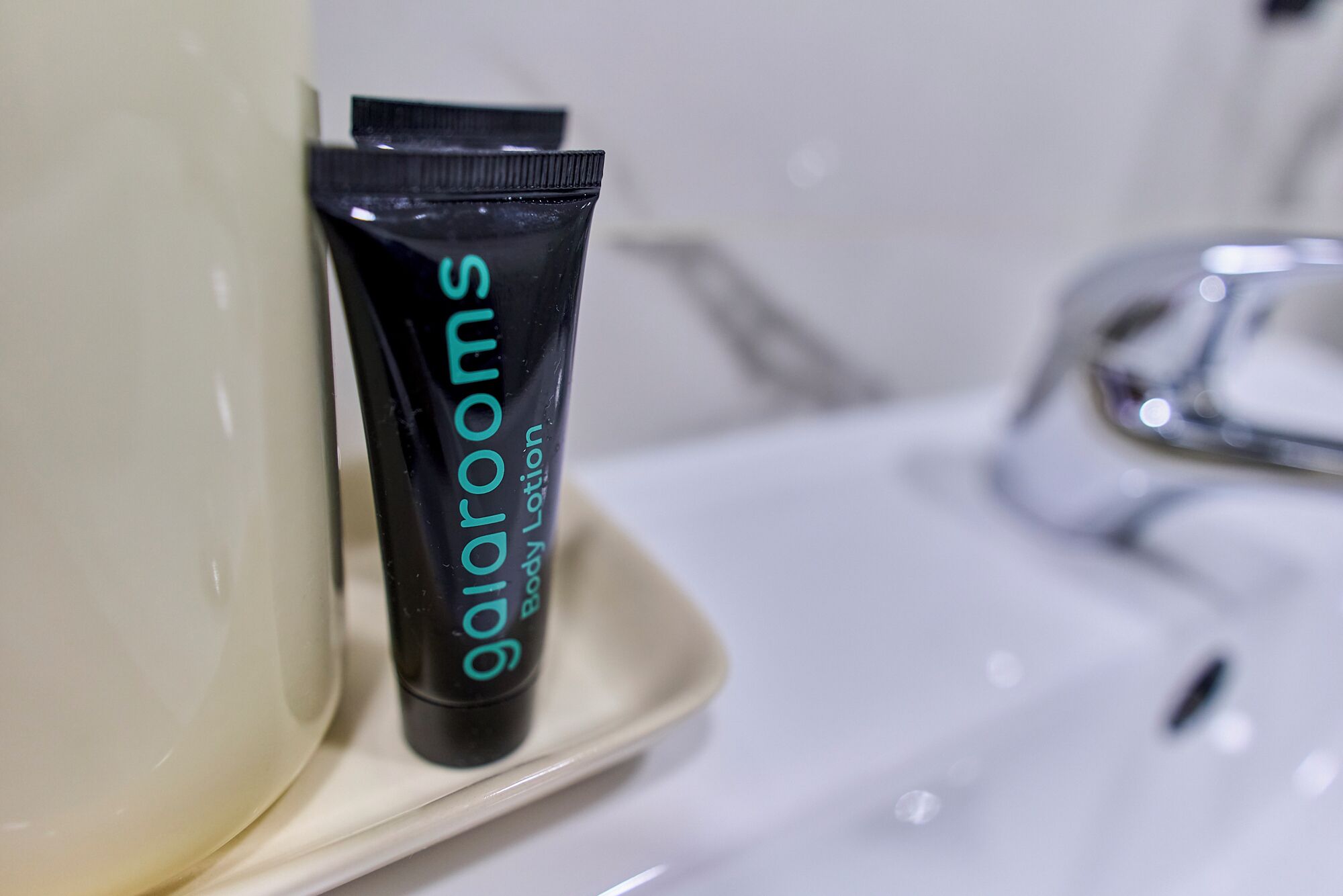 A tube of Galarooms body lotion on a bathroom sink.