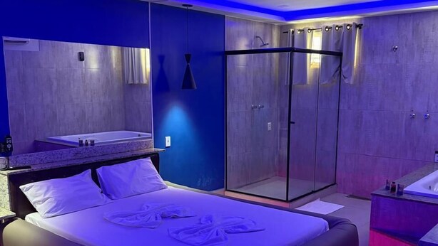 A modern bedroom with a large bed, a separate bathroom, and a walk-in closet. - Motel Laddak (Gama)