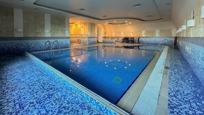 An indoor swimming pool with tiled walls and a clear pool area. - Marina Marvel Room Elite Residences (Dubai)