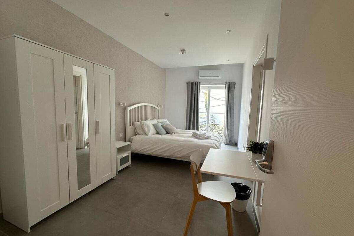 Ein Schlafzimmer mit einem Bett, einem Schreibtisch und einem Kleiderschrank.