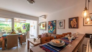 Un comedor moderno con una larga mesa dispuesta para dos personas, rodeada de asientos cómodos.