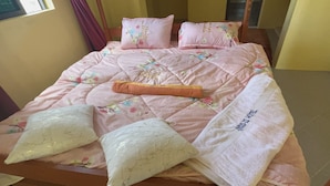 A bed with floral bedding and pillows, a blanket, and a tag reading "Hotel".