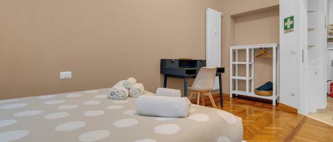 A hotel room with a bed, a desk, a chair, and a wardrobe.