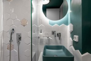 Une salle de bain moderne avec une douche, un lavabo et un miroir.