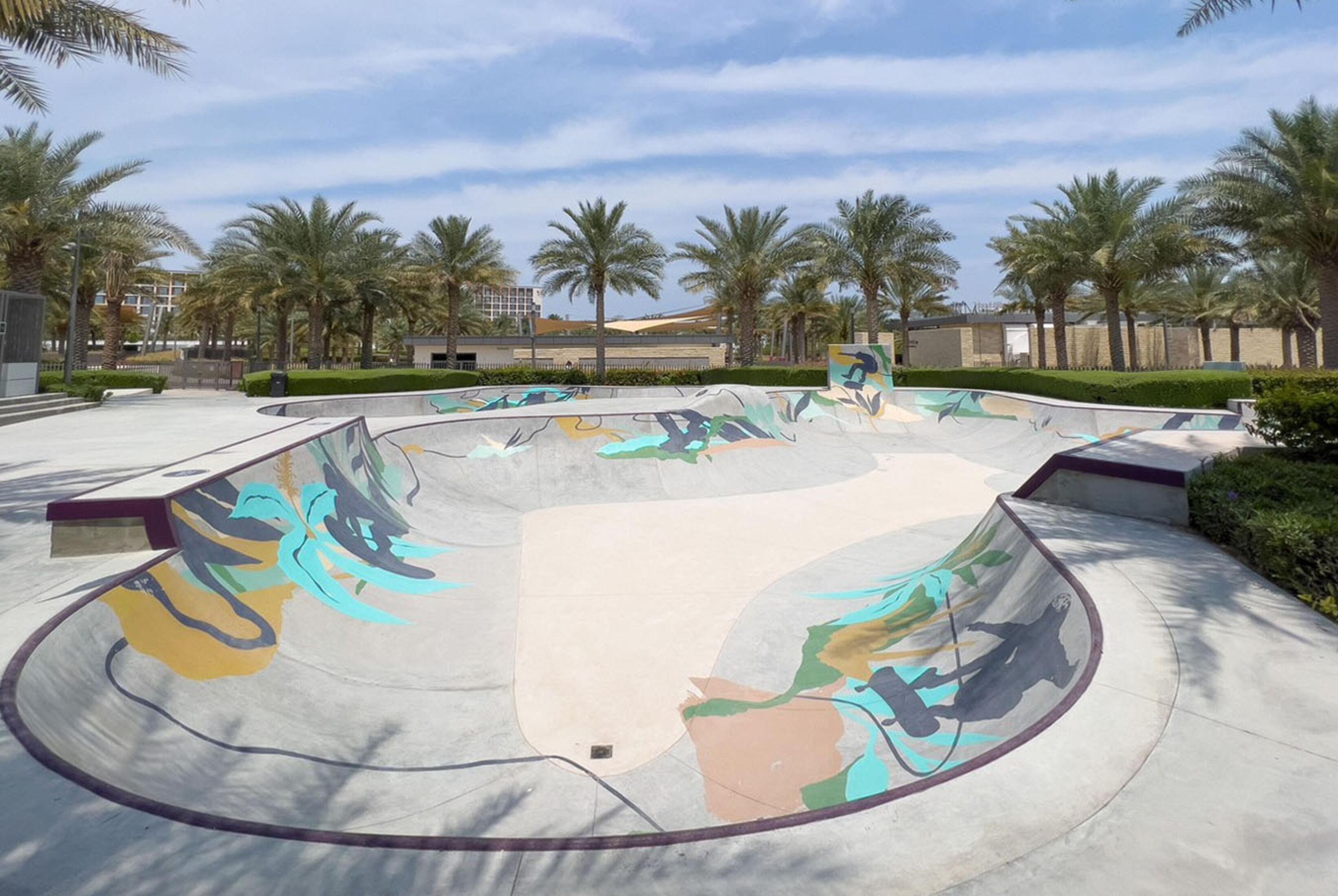A skate park with a curved ramp and graffiti art.