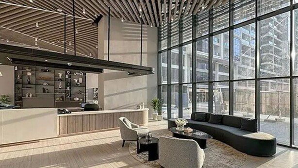 Un intérieur moderne avec une grande fenêtre, un canapé et une table basse.