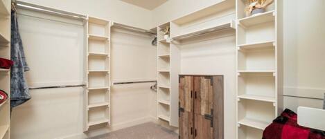 Un dressing avec plusieurs étagères et une armoire en bois.