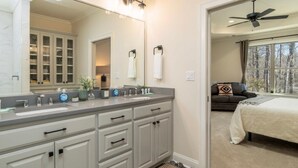 Une salle de bain avec un grand miroir, un meuble-lavabo et une fenêtre.