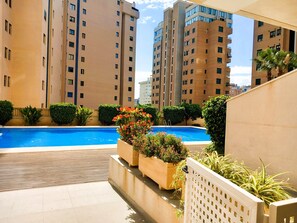 Una piscina rodeada de vegetación y altos edificios residenciales.