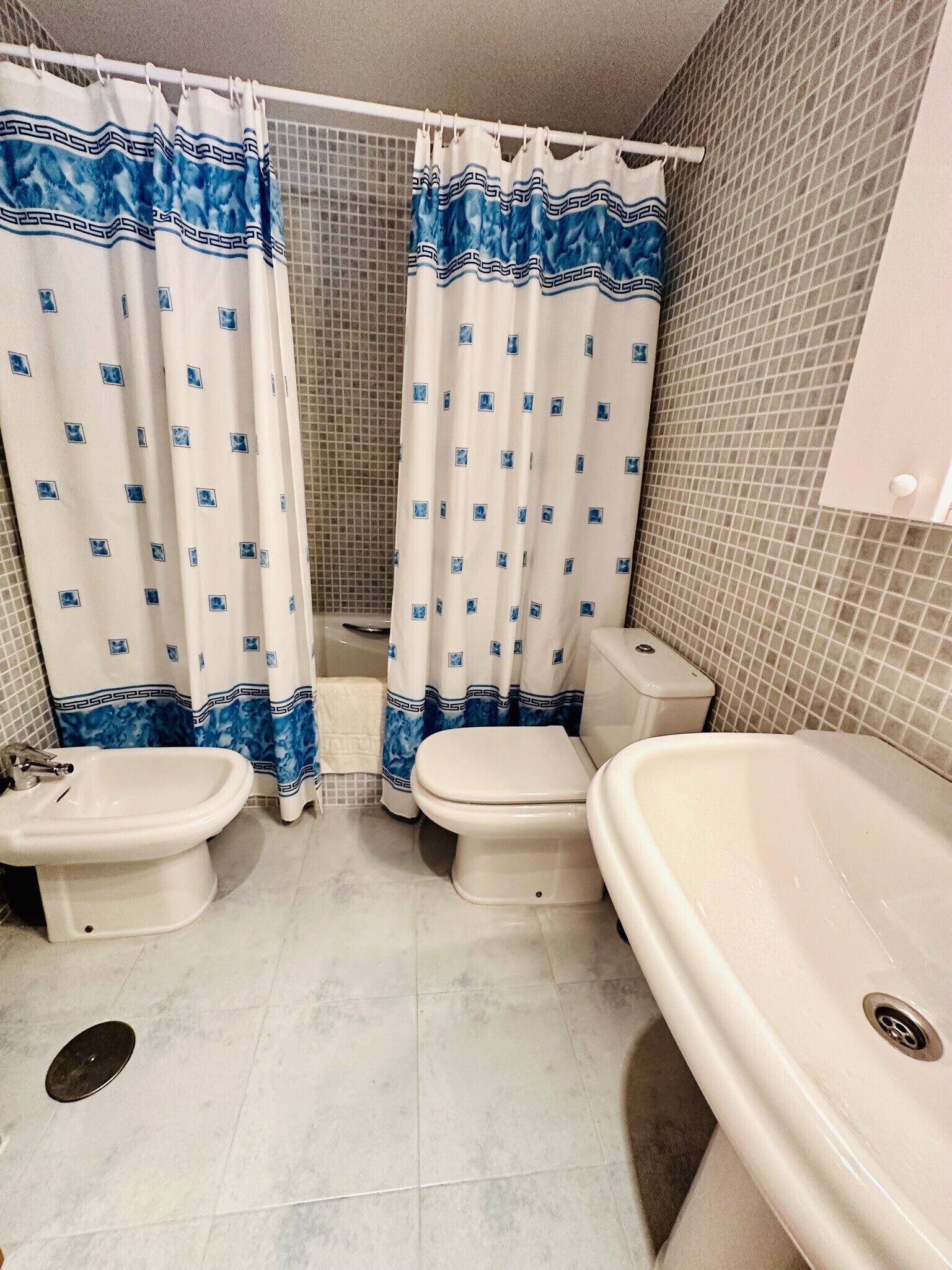 Ein Badezimmer mit zwei Toiletten, einem Bidet und einer Badewanne.