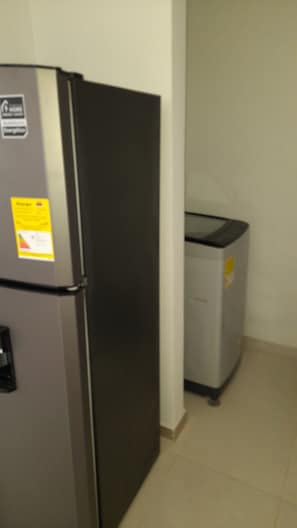 Compact kitchen area with a refrigerator and oven, perfect for preparing meals.