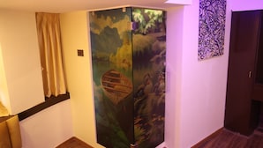 A room with a sliding door featuring a nature scene, a wooden floor, and a wall-mounted artwork. - Hotel Air Stay Inn (Mumbai)
