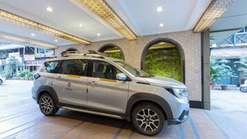 A silver SUV parked in a hotel lobby with a modern design, including hexagonal patterned walls and a large arched window.