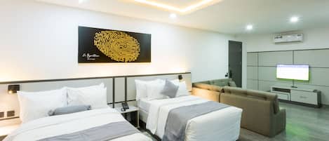 A hotel room with two beds, a sofa, a TV, and a large artwork on the wall.