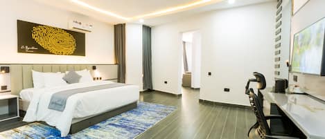 A modern hotel room with a large bed, a desk, and a television.
