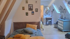 A bedroom with a bed, a desk, and a dresser. There are pictures on the wall and a skylight above the desk. - Maison de Vacances au Calme , à 5 Minutes de la Capitale de la Préhistoire ! (Tursac)