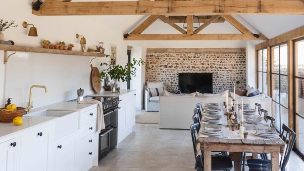 A spacious kitchen with white cabinetry, a wooden ceiling, and a stone wall. - Poplars Farm Barns, Brand new stunning thatched barn conversion (Chichester)