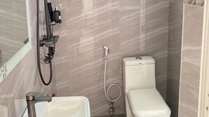 A bathroom with a shower, toilet, and sink. - Luckysmallie 1-bed Apartment in Goba (Dar es Salaam)
