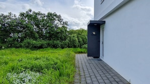 A modern building with a paved pathway leading to a dark entrance. - VIU2 Hannover (Hannover)