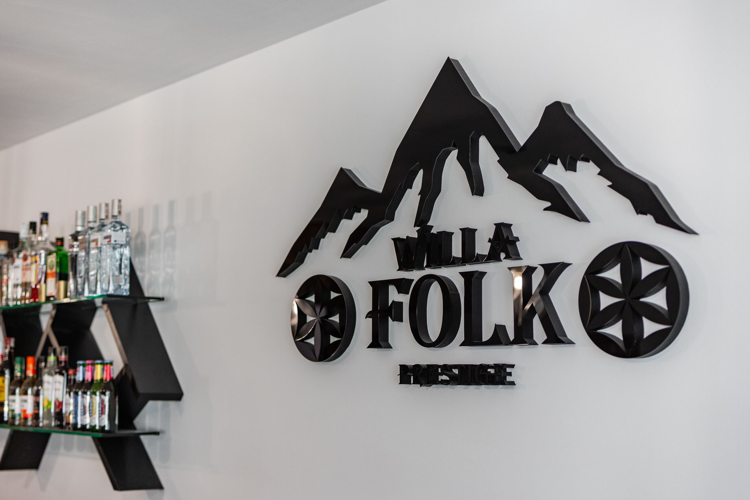 A wall with a mountain logo and the text "Willa Folk House".