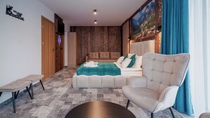 A modern bedroom with a large bed, a sofa, a round coffee table, and a bench. - Willa Folk & Prestige (Zakopane)