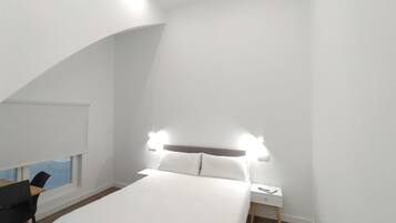 Une chambre à coucher moderne avec un lit, une table de chevet et une chaise.