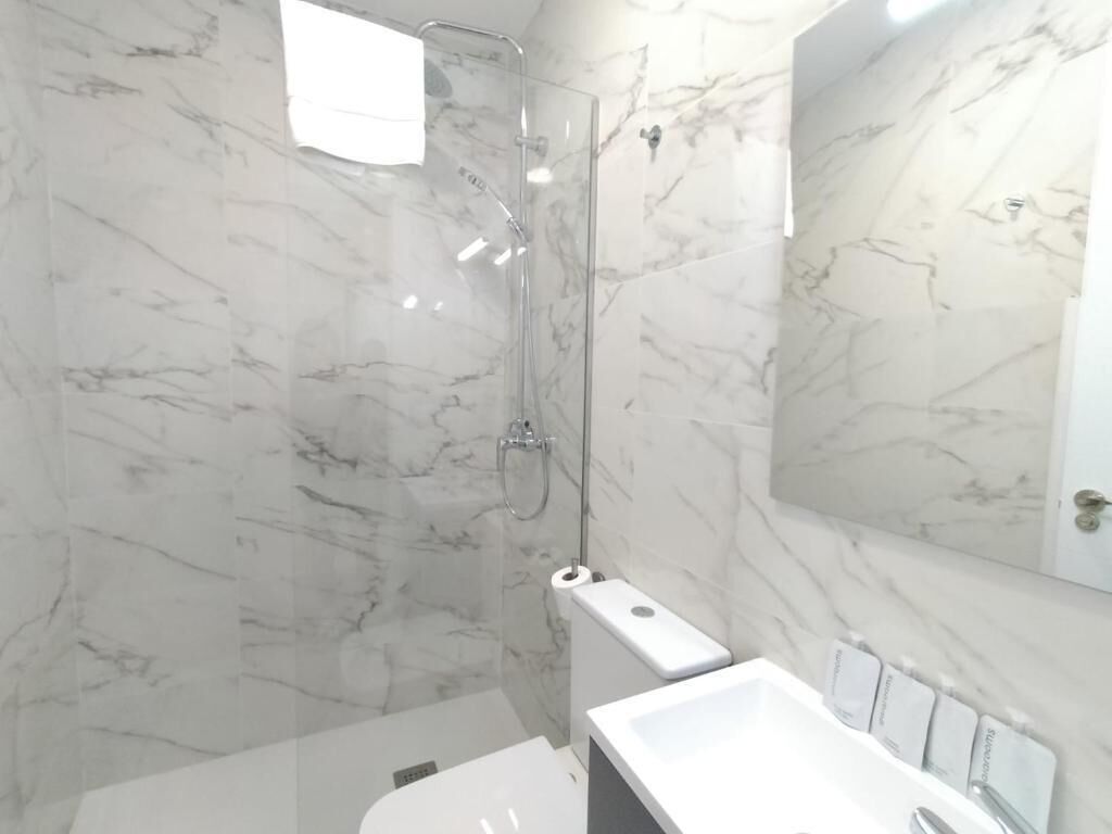 Appartement | Badkamer | Een douche, een haardroger, handdoeken, zeep