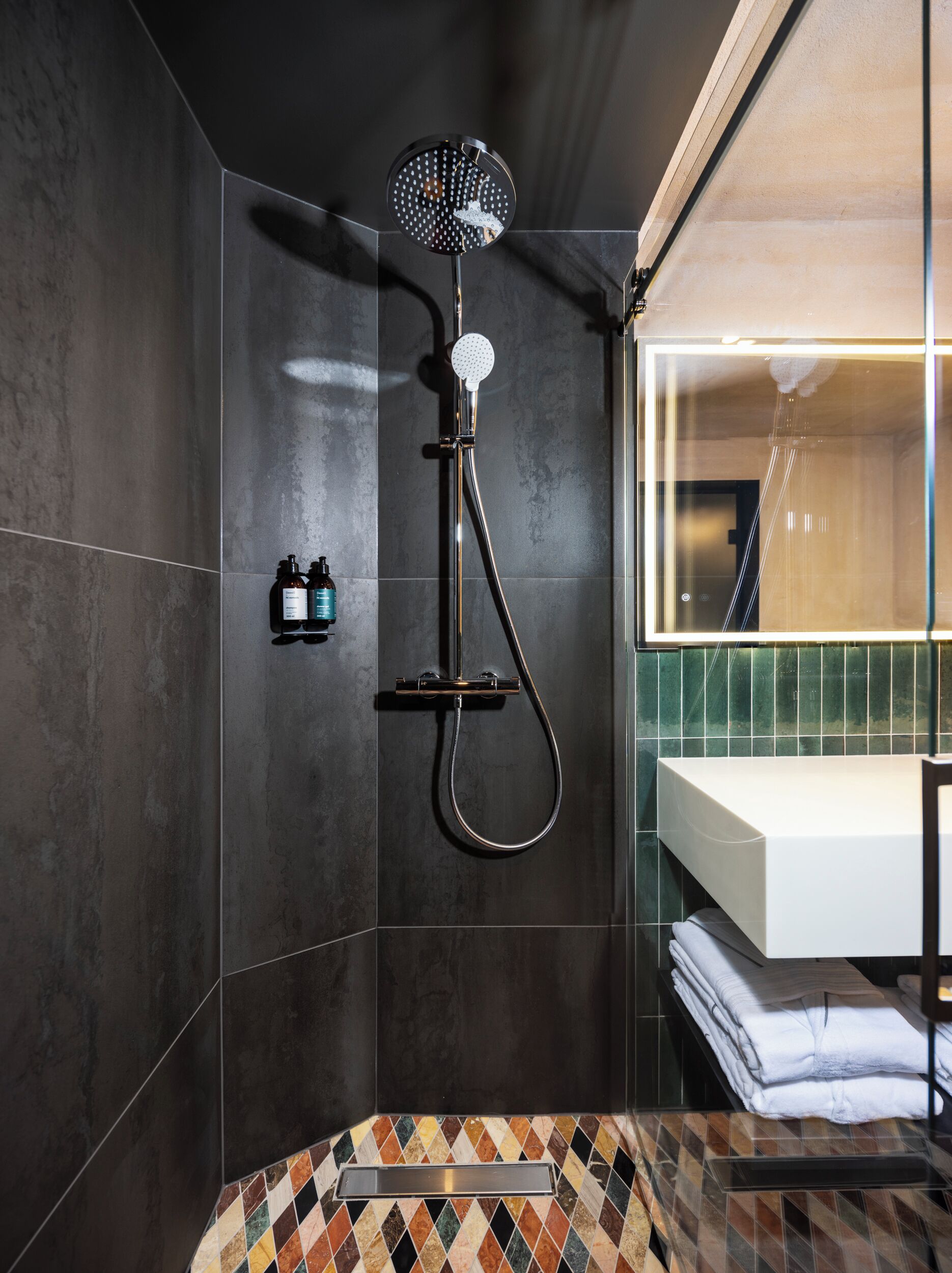 Un baño moderno con ducha, lavabo y espejo.