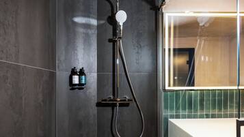 Un baño moderno con ducha, lavabo y espejo.