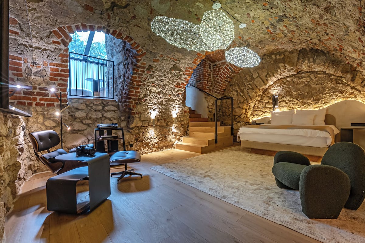 Ein gemütliches Zimmer mit Stehwänden, einem Bett, einem Schreibtisch und einem Sessel.