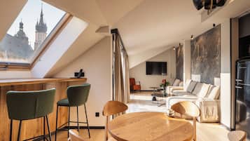 Un loft moderno con techo alto, tragaluces, comedor, cocina y sala de estar.