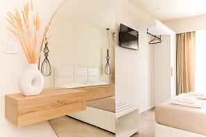 A modern bedroom with a wooden bedside table, a white headboard, a flat-screen TV mounted on the wall, and a hanging coat rack. - Mystery suites & apartments (Dio-Olympos)