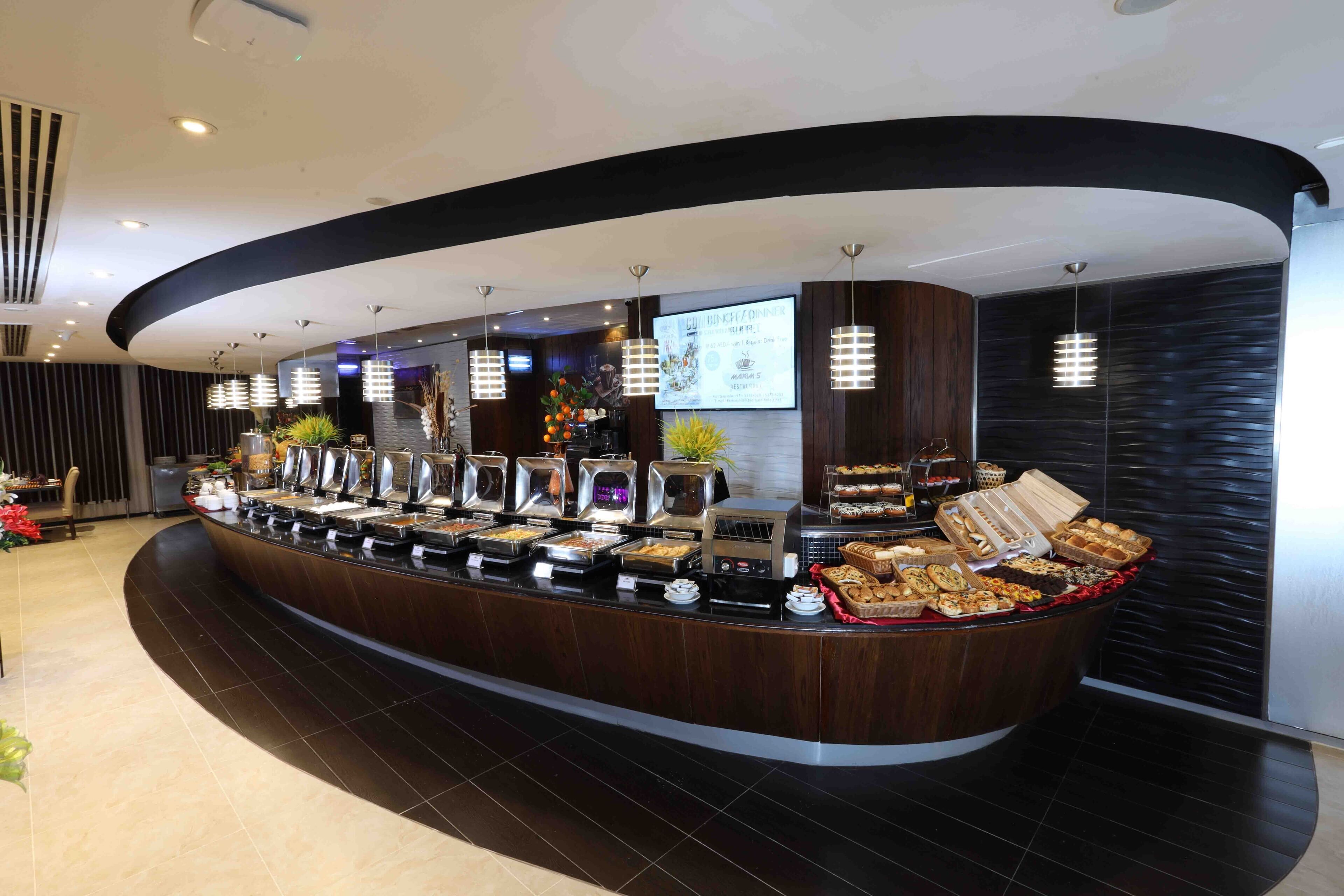 A buffet counter with various food items and a digital screen displaying menu options.