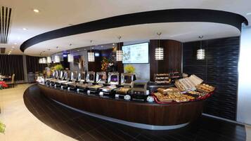 A buffet counter with various food items and a digital screen displaying menu options.