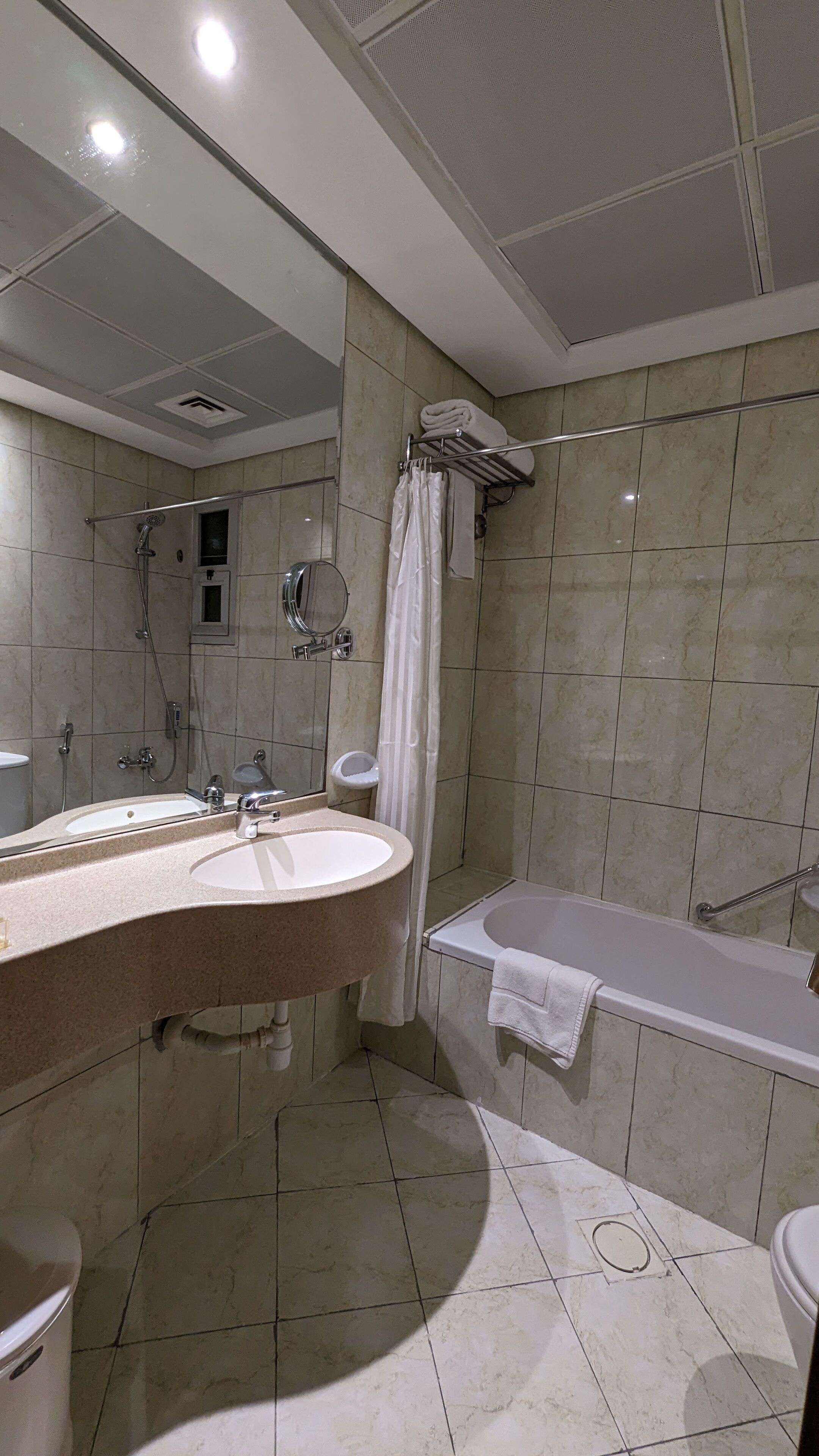 A bathroom with a sink, mirror, shower, and bathtub.