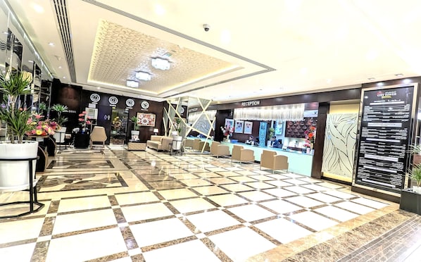 A hotel reception area with a check-in counter, seating area, and a reception desk.